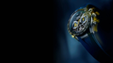 Luxury men's chronograph watch with blue strap, black dial, yellow accents, and tachymeter bezel
